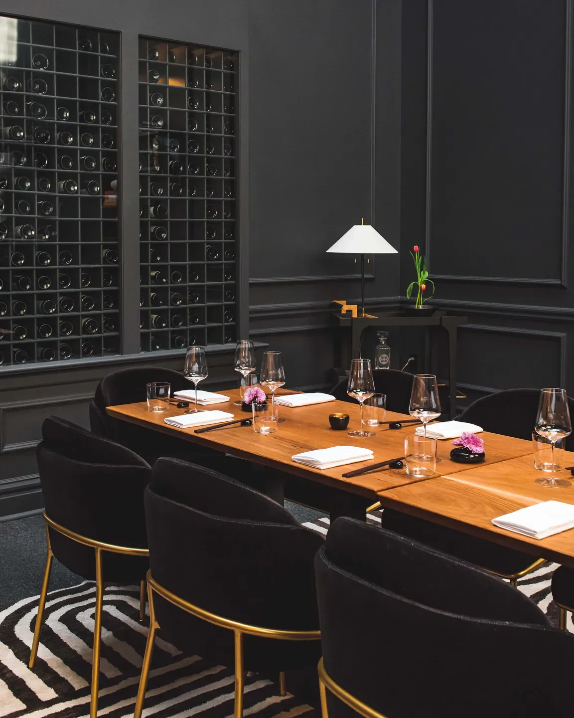 Elegant dining room interior at Nisei restaurant in San Francisco with wine display.