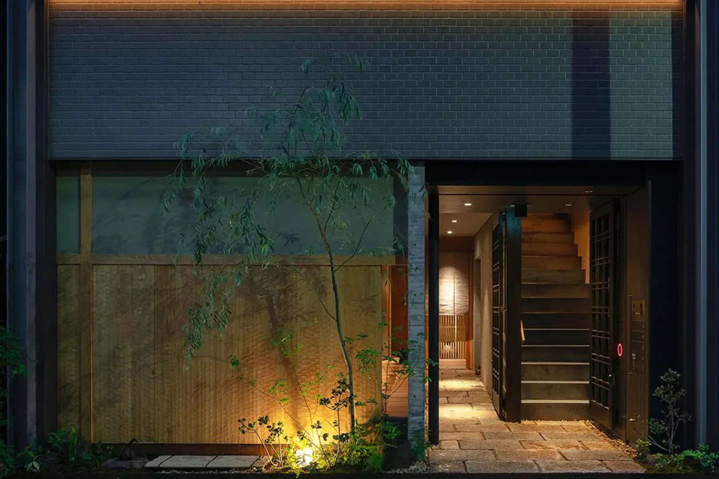 Entrance to Nishino restaurant in Osaka, Japan, featuring a stone path and illuminated doorway.