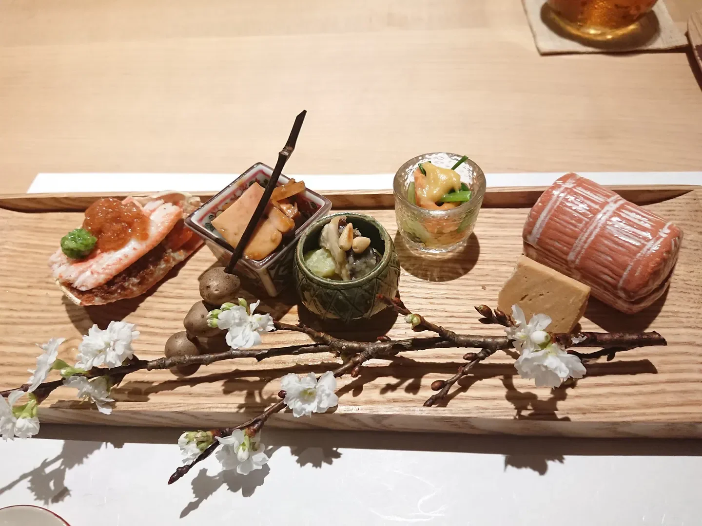 Delicious Japanese appetizers at Nishitemma Nakamura restaurant in Osaka, beautifully arranged with flowers.