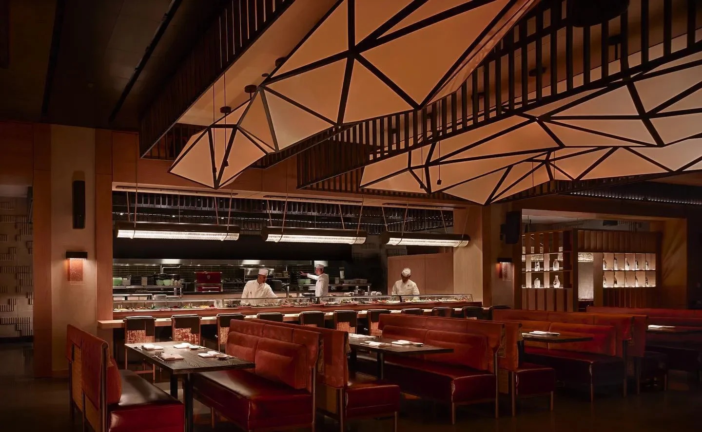 Elegant dining area at Nobu Atlanta, with chefs preparing food at the sushi bar.