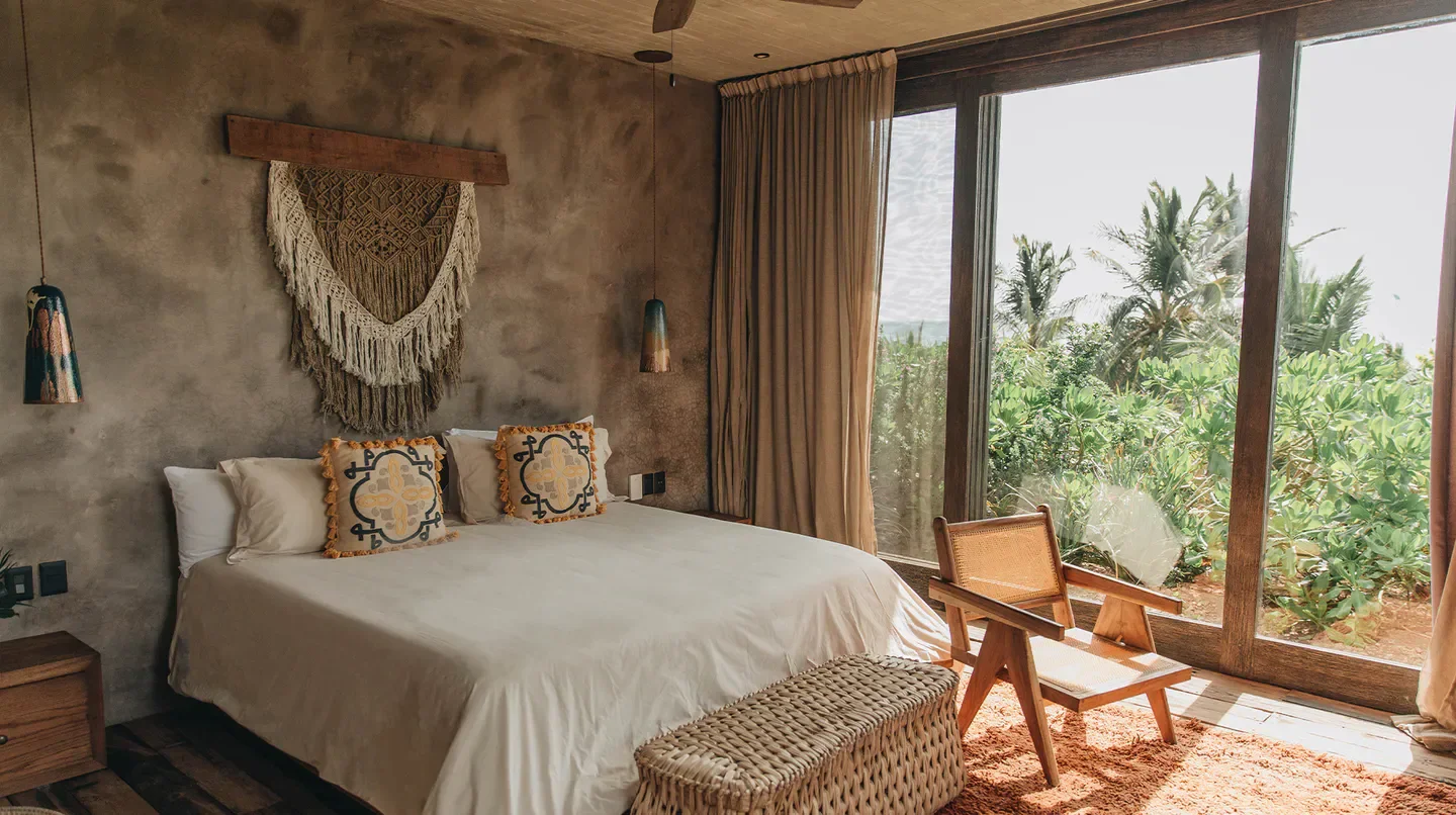 Cozy bedroom at Nômade Tulum hotel in Tulum with natural light and stylish decor.