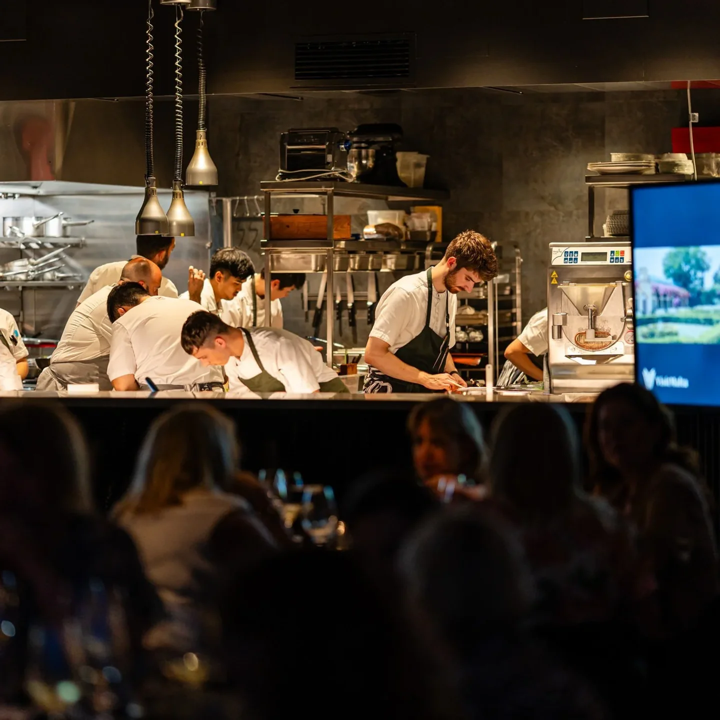 Chefs working in the bustling kitchen at Noni restaurant in Malta, showcasing a dynamic culinary environment.