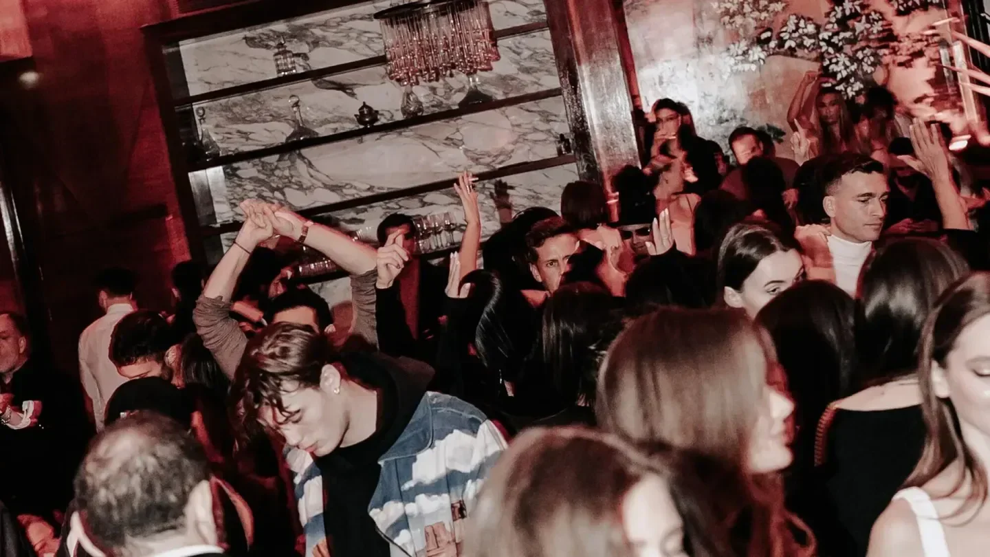 Energetic crowd at NOTO restaurant in Paris, enjoying drinks and dancing.