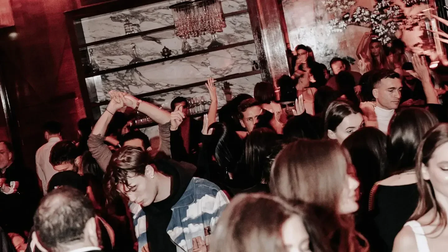 Energetic crowd at NOTO restaurant in Paris, enjoying drinks and dancing.