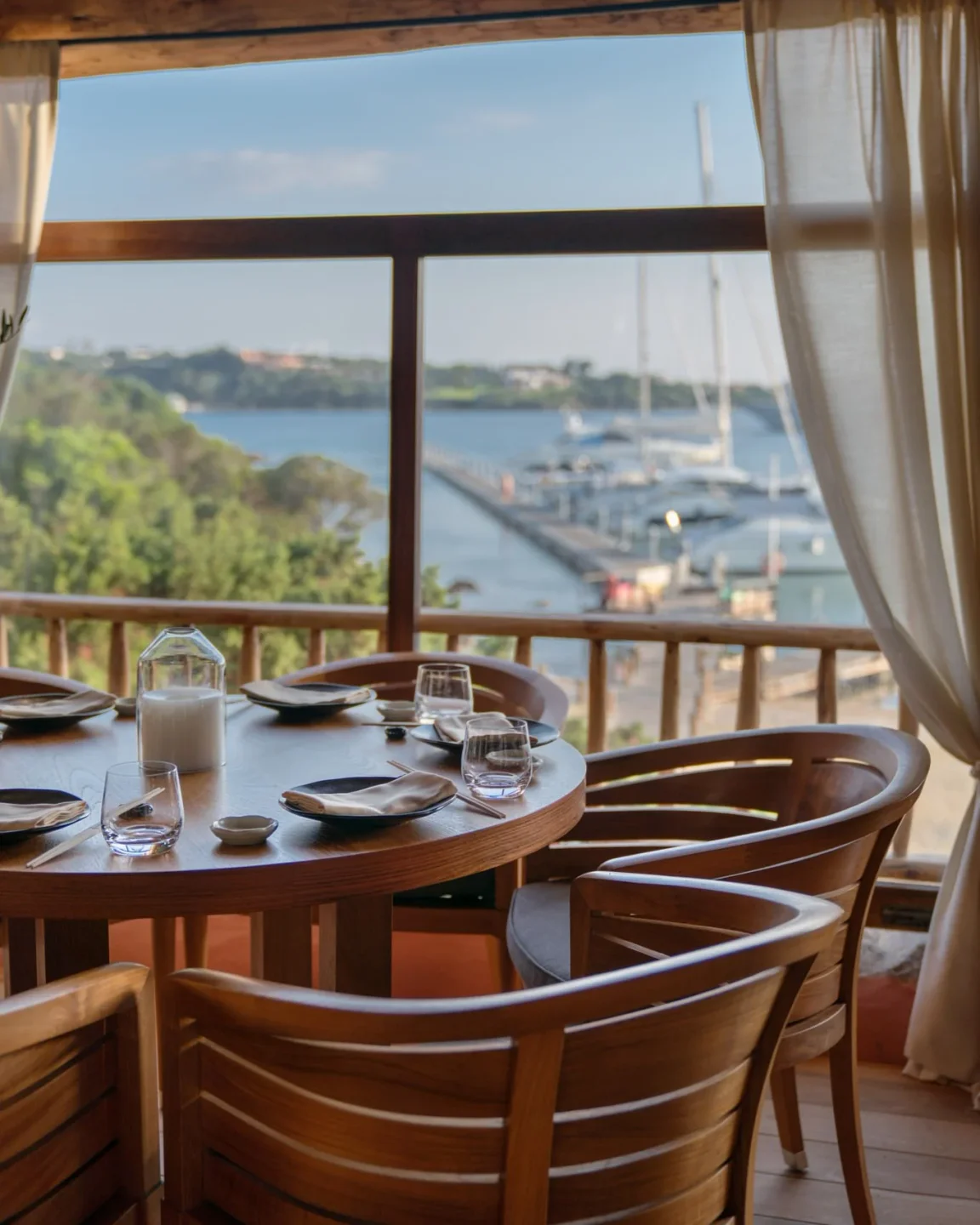 Elegant dining table at Novikov restaurant in Porto Cervo with a view of the marina and yachts.