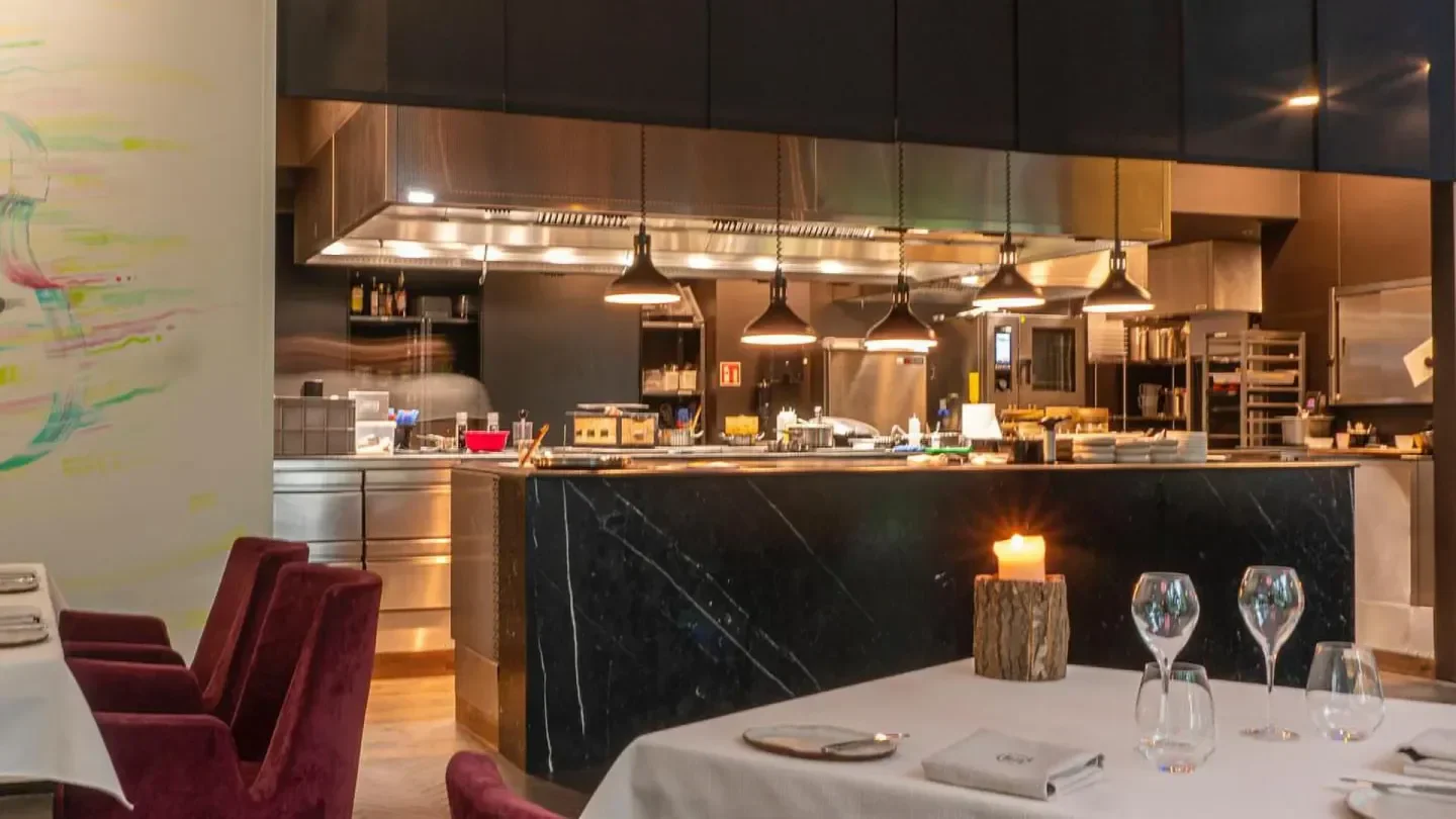 Interior view of the open kitchen at NUTA restaurant in Warsaw, featuring a marble bar