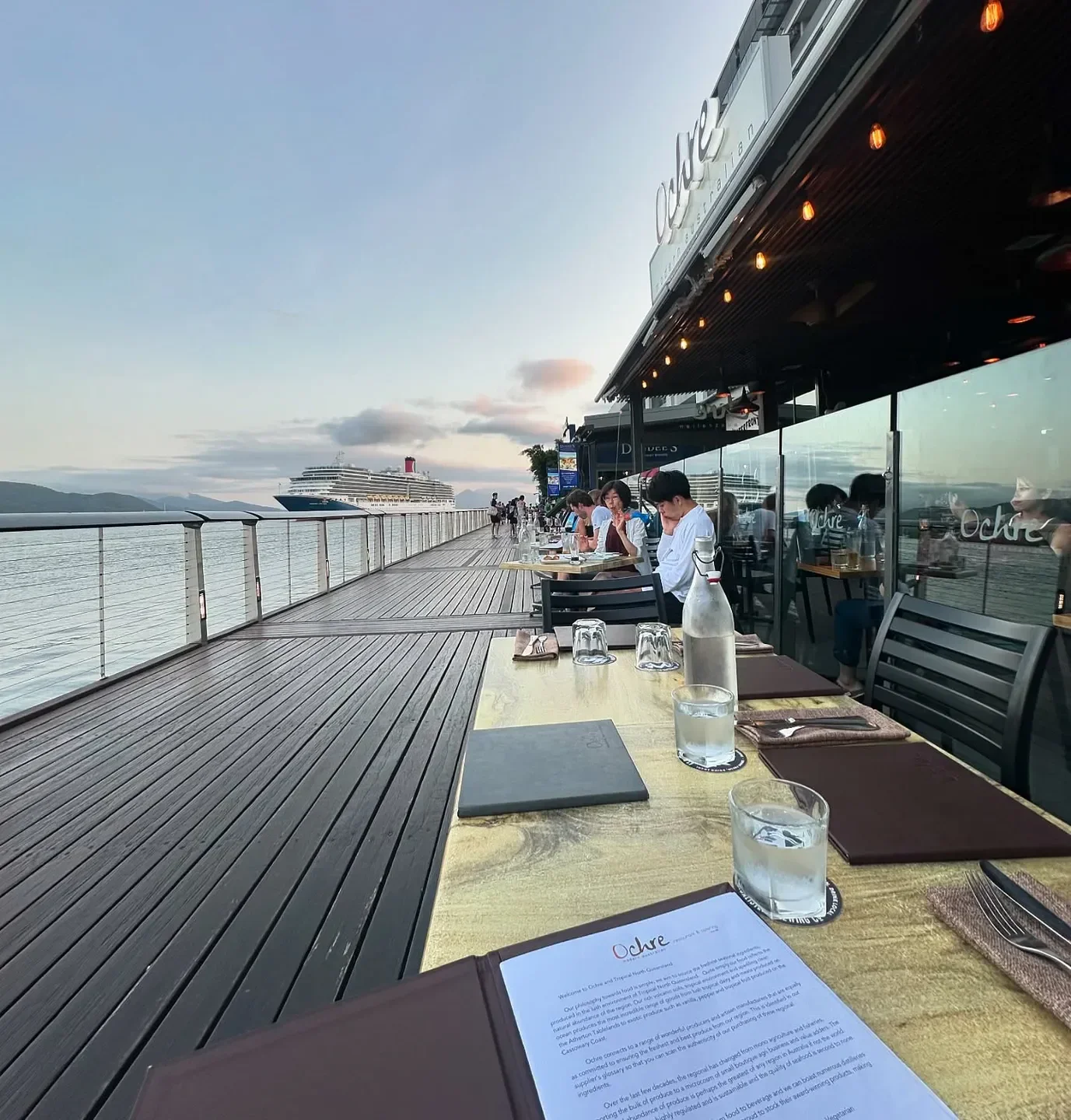 Dining at Ochre Restaurant in Cairns, waterfront view with a cruise ship in the distance