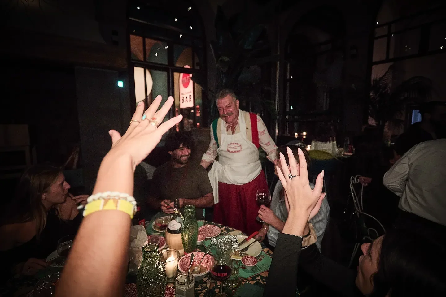 Festive scene at Officina della Bistecca in Tuscany, celebrating a meal with friends.
