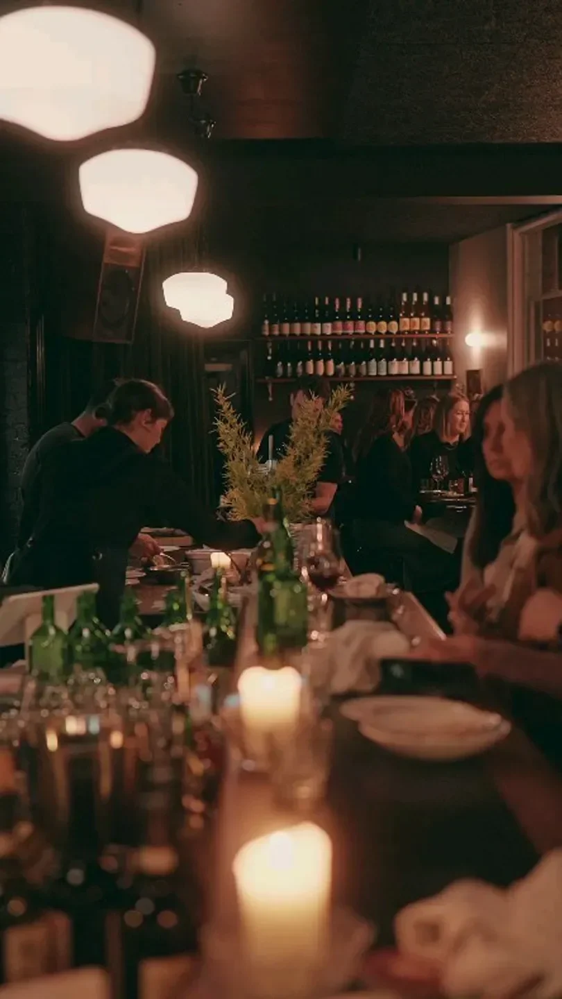 Cozy dining experience at Ogee restaurant in Hobart, with candlelight and wine bottles.