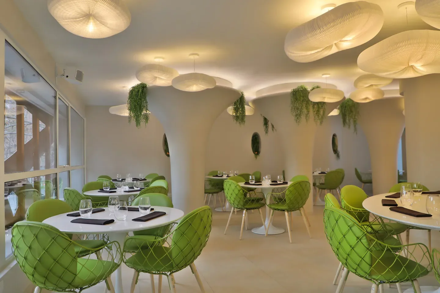 Interior of Olam restaurant in Santiago, featuring unique lighting and green chairs.