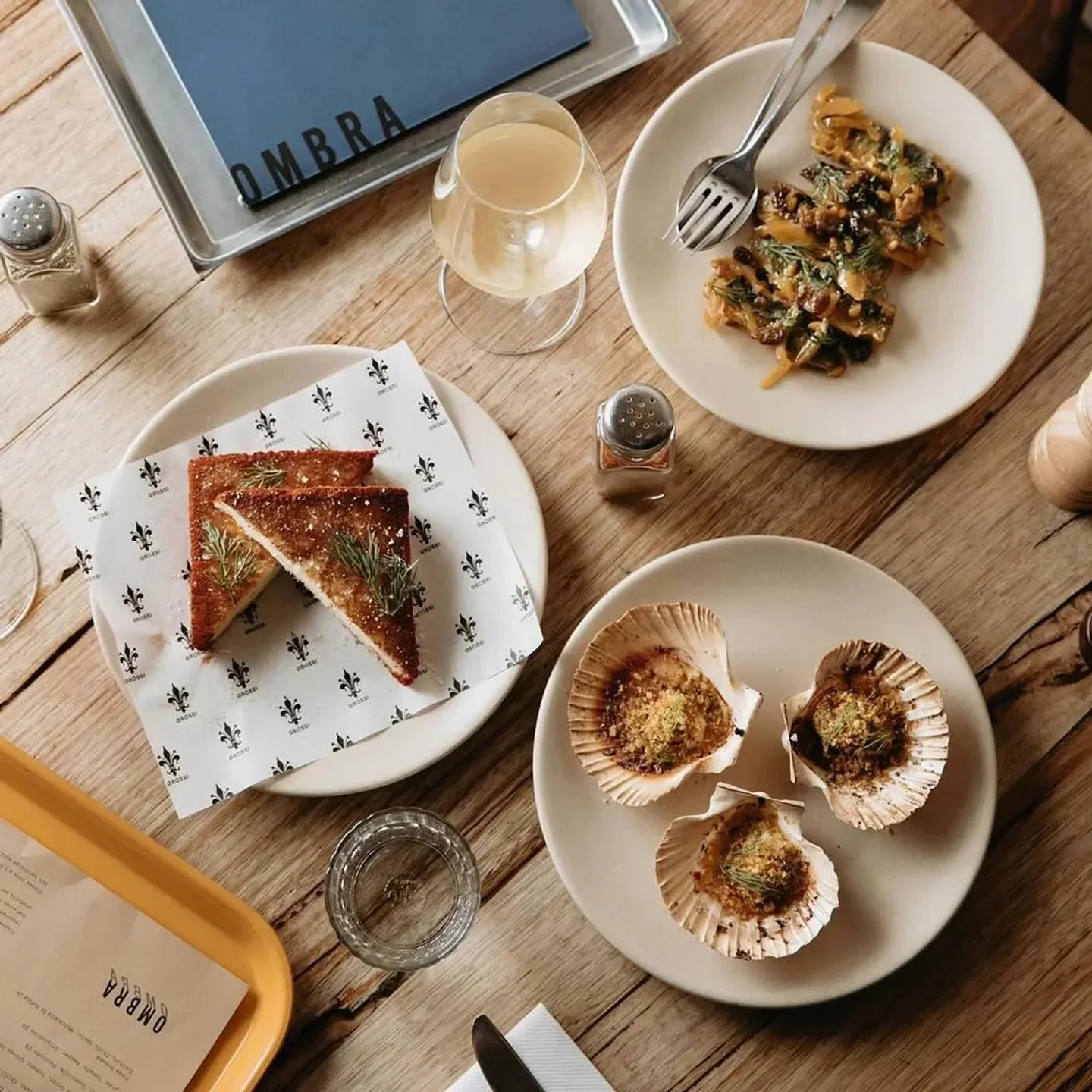 Delicious dishes at Ombra restaurant in Melbourne, including scallops and toasted bread.