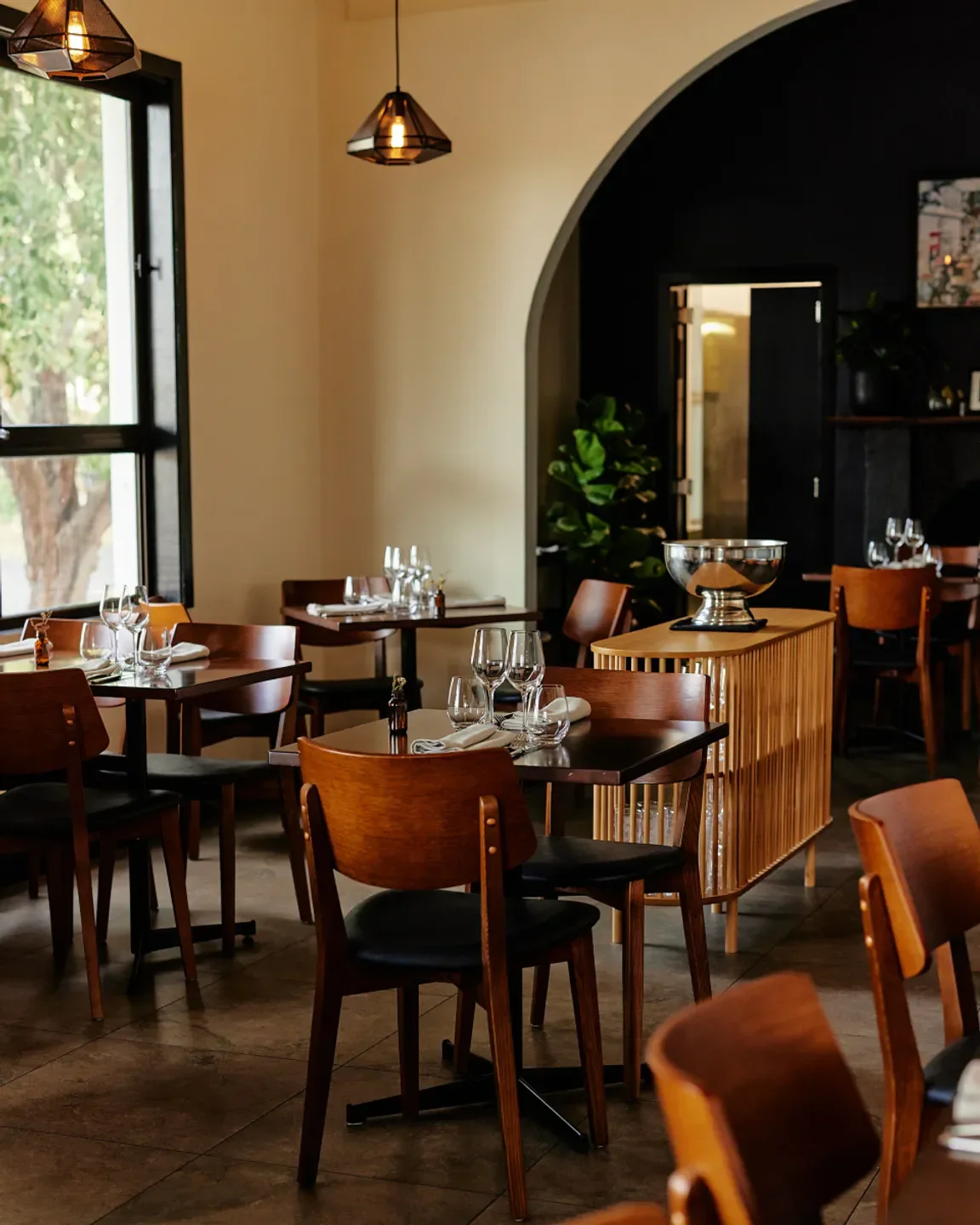 Interior of Omen Albert Park in Melbourne, showcasing dining tables and elegant decor.