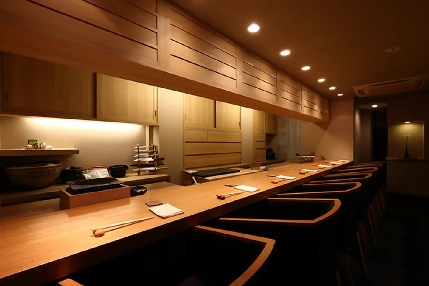 Interior of Onarimon Haru restaurant in Tokyo, featuring a sushi bar and wooden decor.