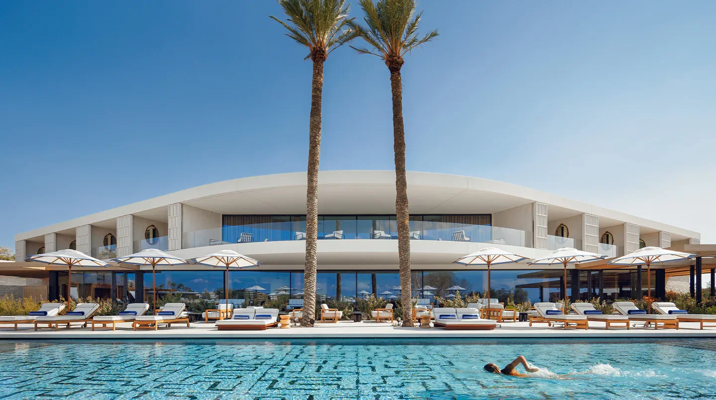 Swimming pool at One&Only Aesthesis in Athens, luxurious hotel with palm trees.
