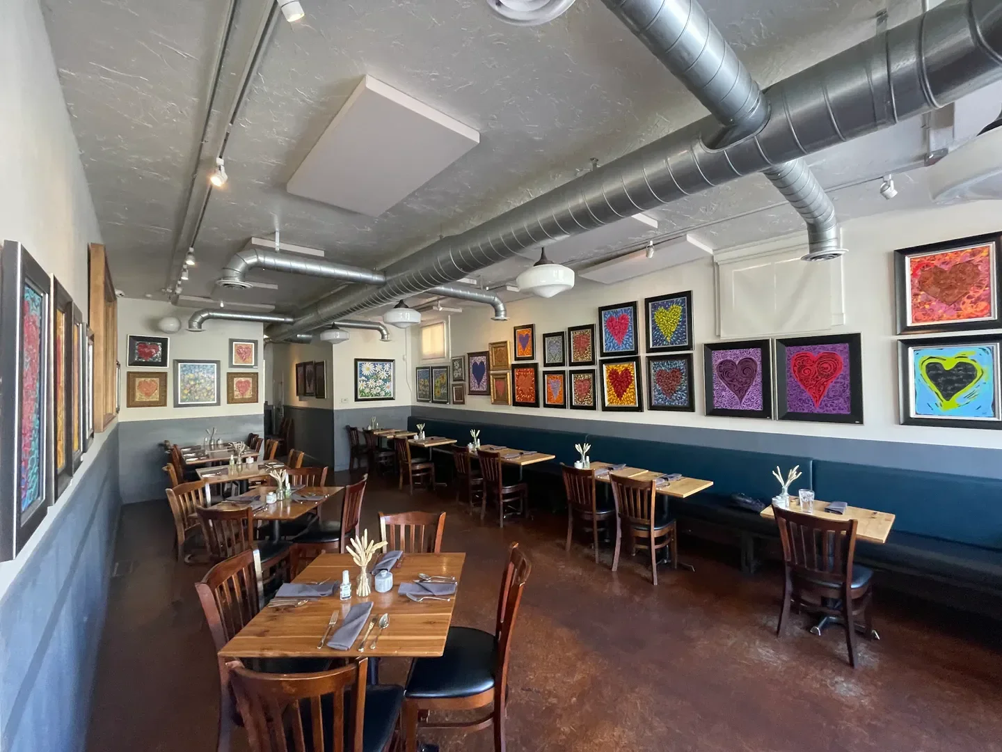 Interior of Oquirrh restaurant in Salt Lake City, showcasing art and dining tables.