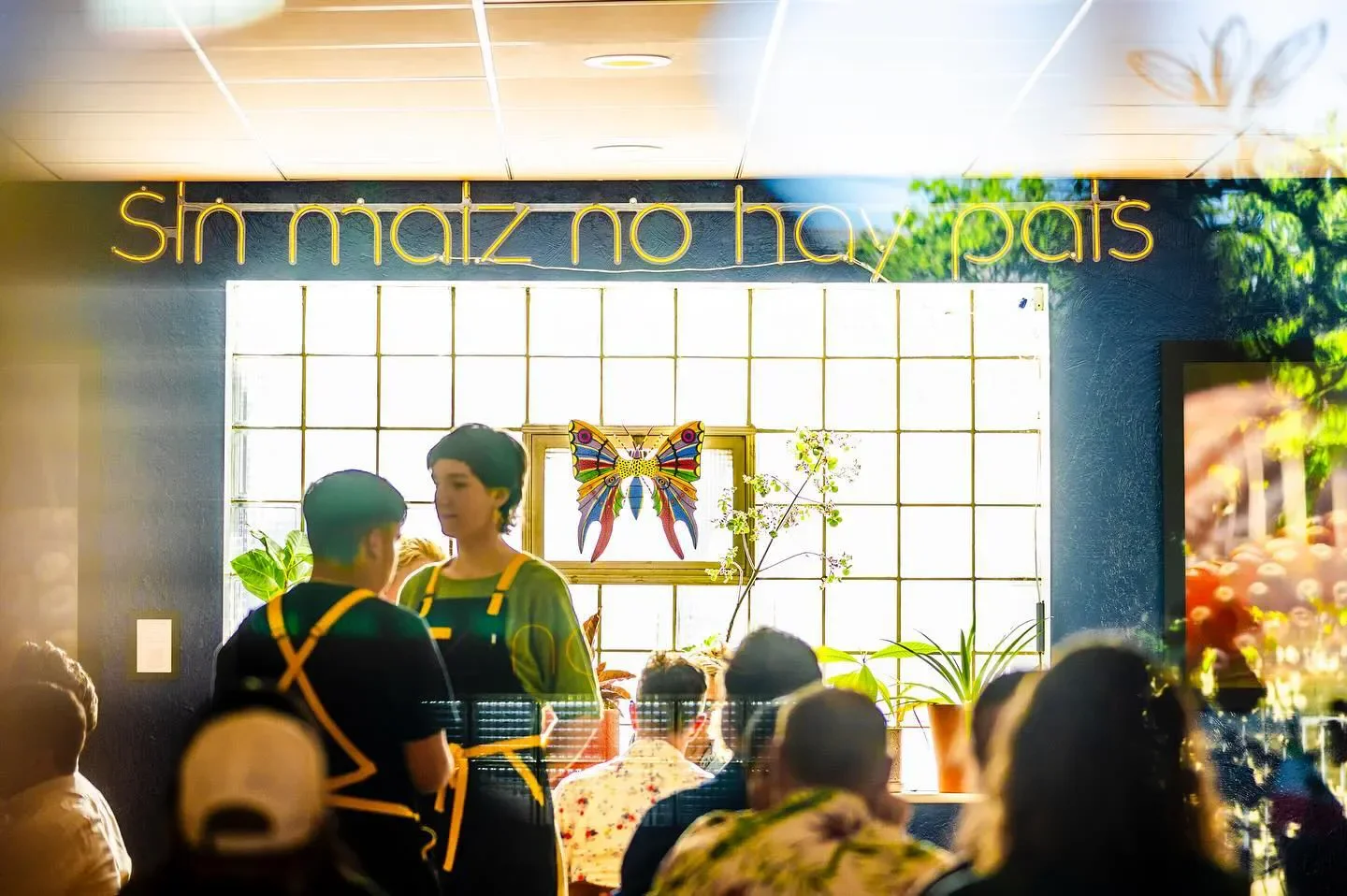 Interior scene at Oro by Nixta in Minneapolis with neon sign and colorful art.
