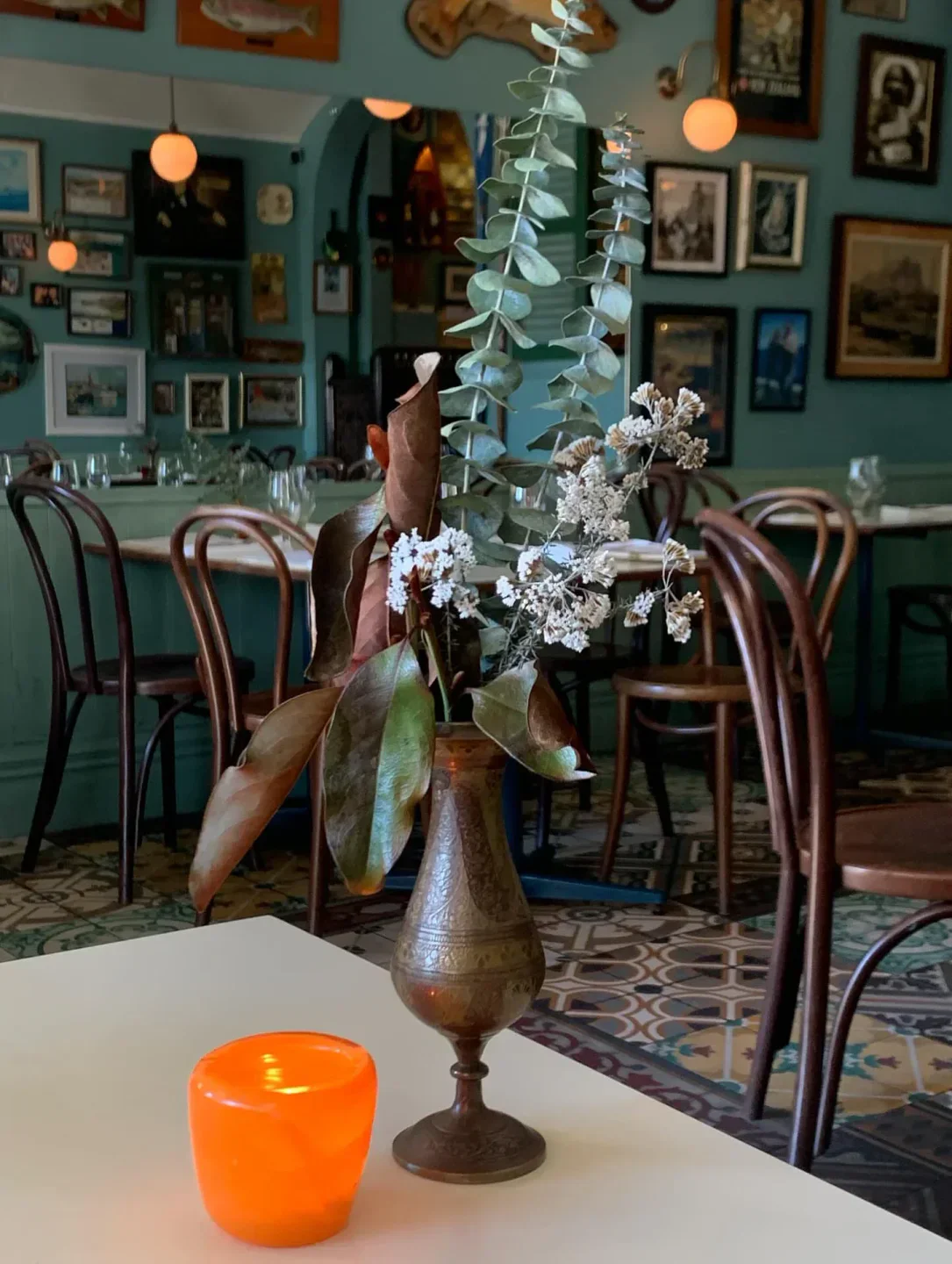 Table setting inside Ortega Fish Shack in Wellington with floral centerpiece and candle.