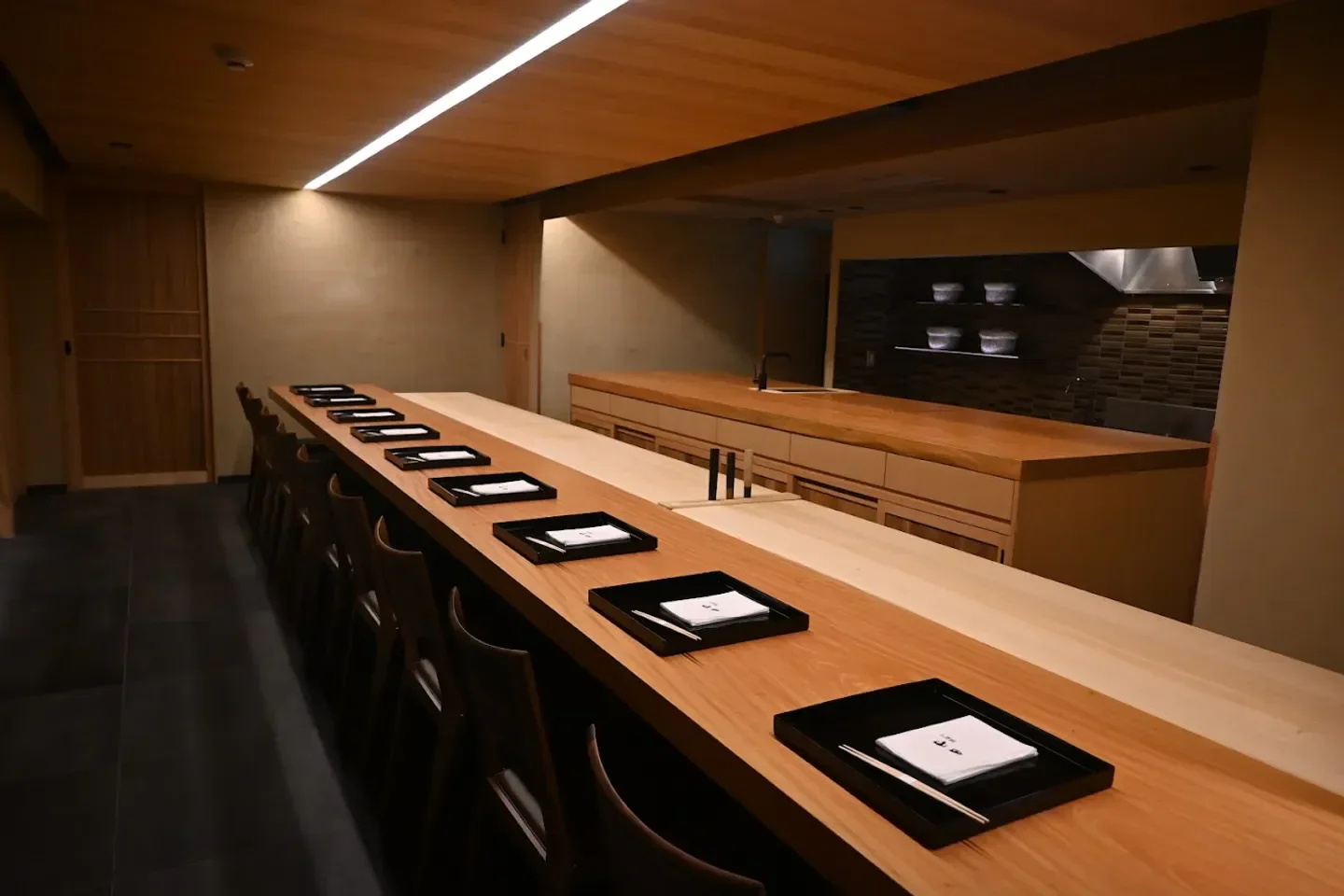 Interior of Oryori Yamada restaurant in Osaka, featuring a wooden sushi bar setting.