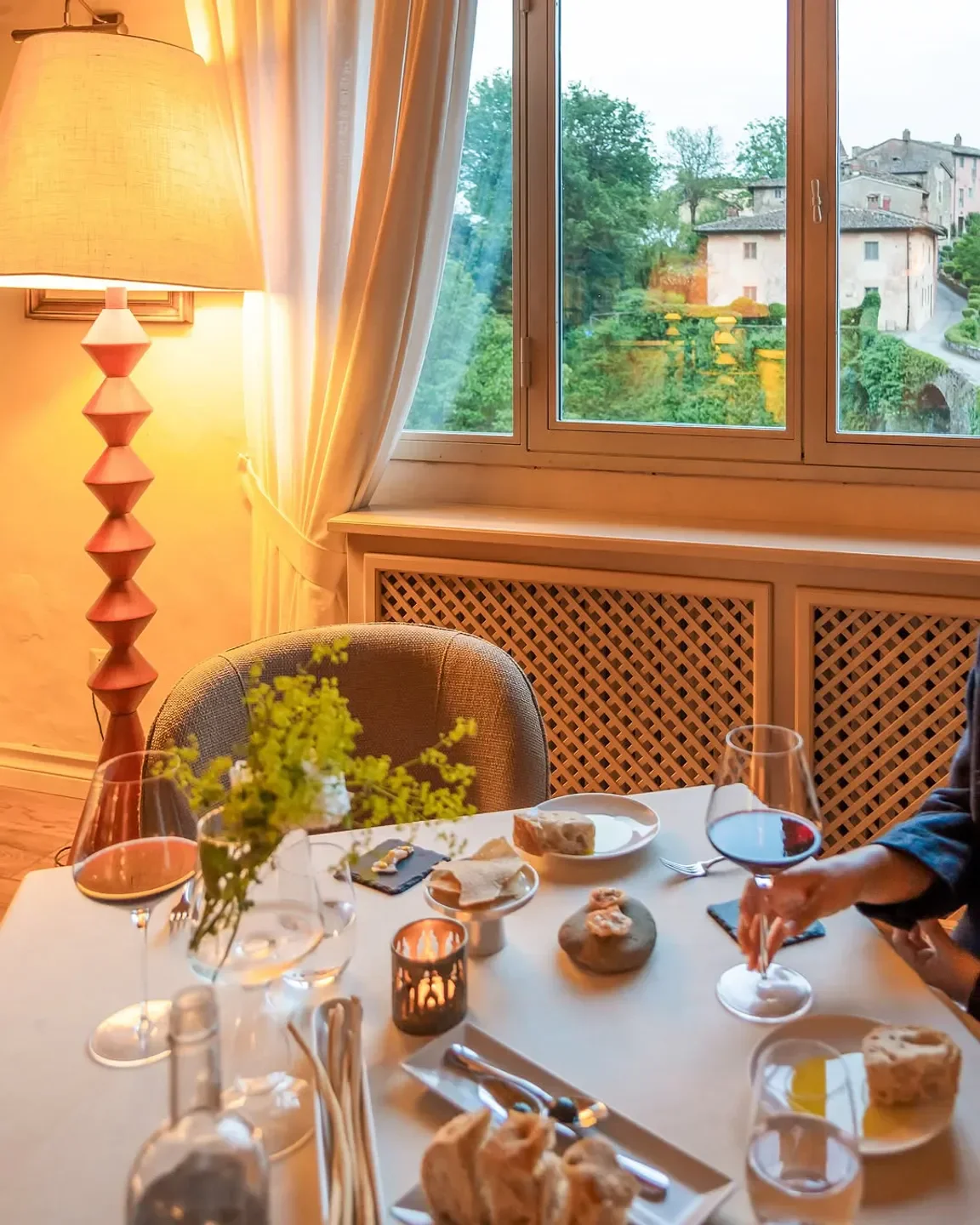 Cozy dining experience at Osteria Del Borro in Tuscany with wine and a charming view.