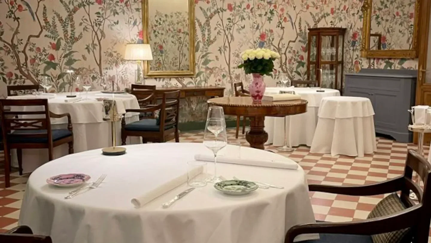Elegant dining room at Osteria del Viandante in Emilia-Romagna, Italy, with floral wallpaper.