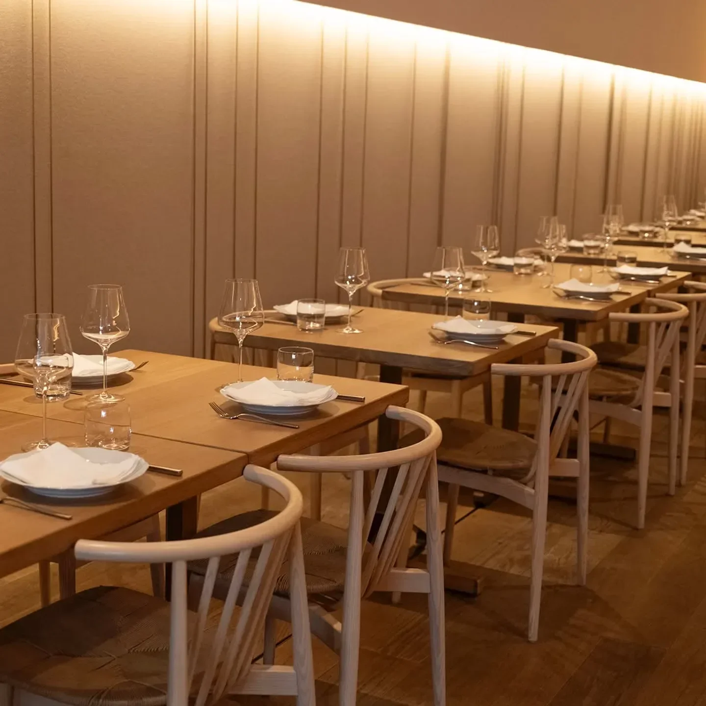 Interior of Osteria Giulia in Toronto, featuring elegant dining tables and chairs.