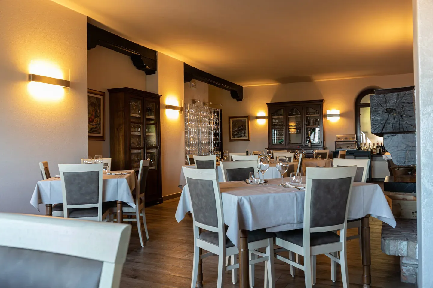 Cozy dining room at Osteria La Torre in Langhe with tables set for dinner.