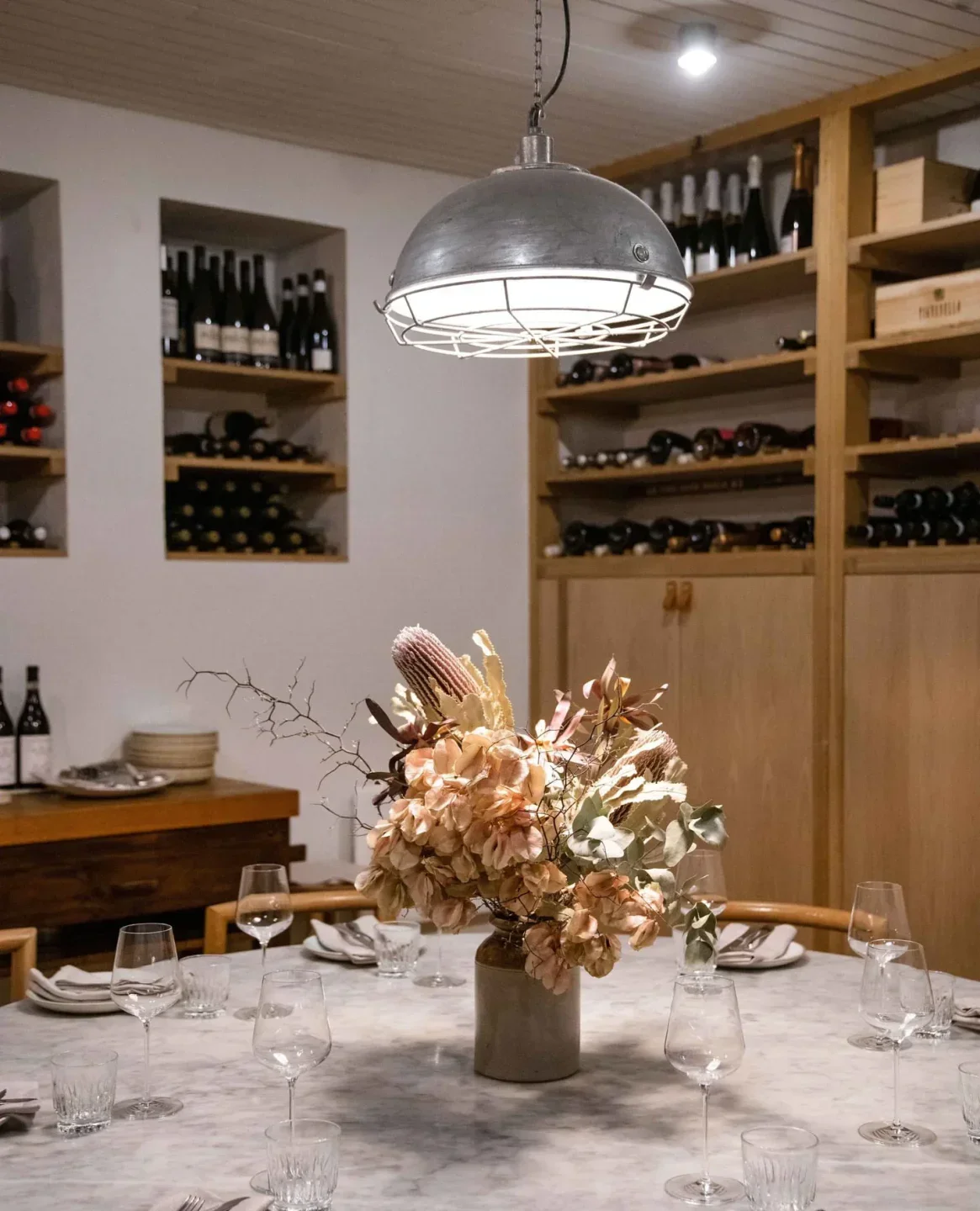 Elegant dining at Osteria Oggi in Adelaide, featuring floral centerpiece and wine selection.