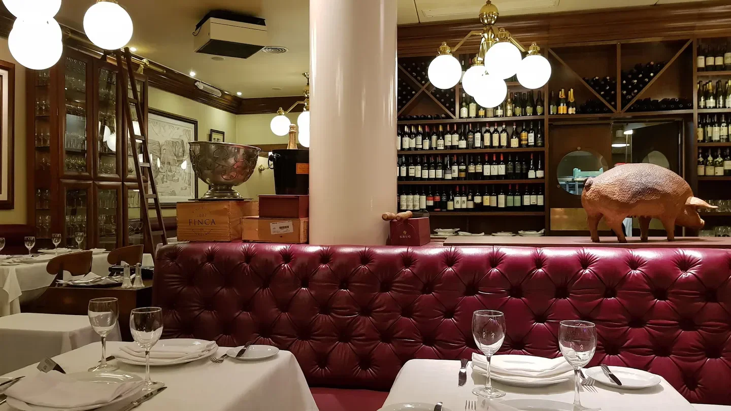 Interior of Oviedo restaurant in Buenos Aires with wine bottles and tables.
