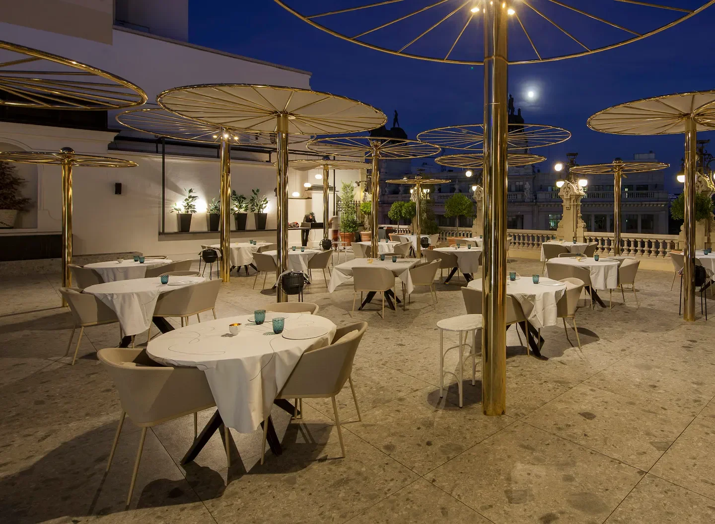Outdoor dining at Paco Roncero restaurant in Madrid with elegant gold accents