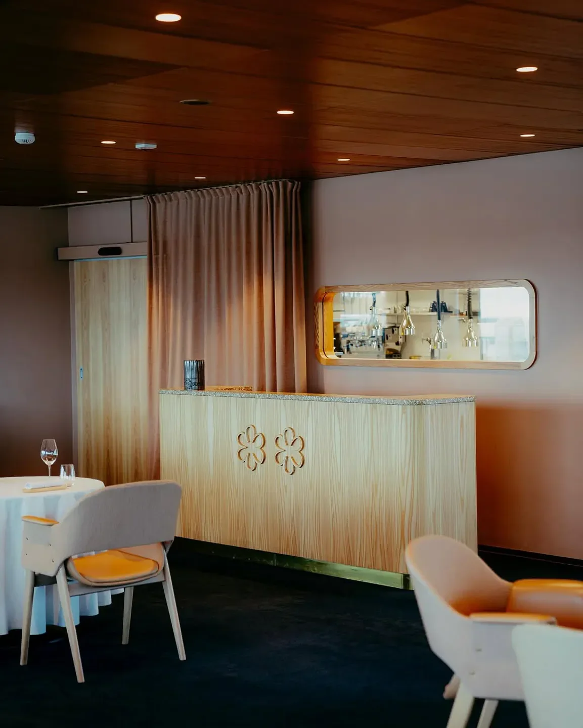 Elegant dining interior at Palace restaurant in Helsinki, featuring wooden details and cozy chairs.