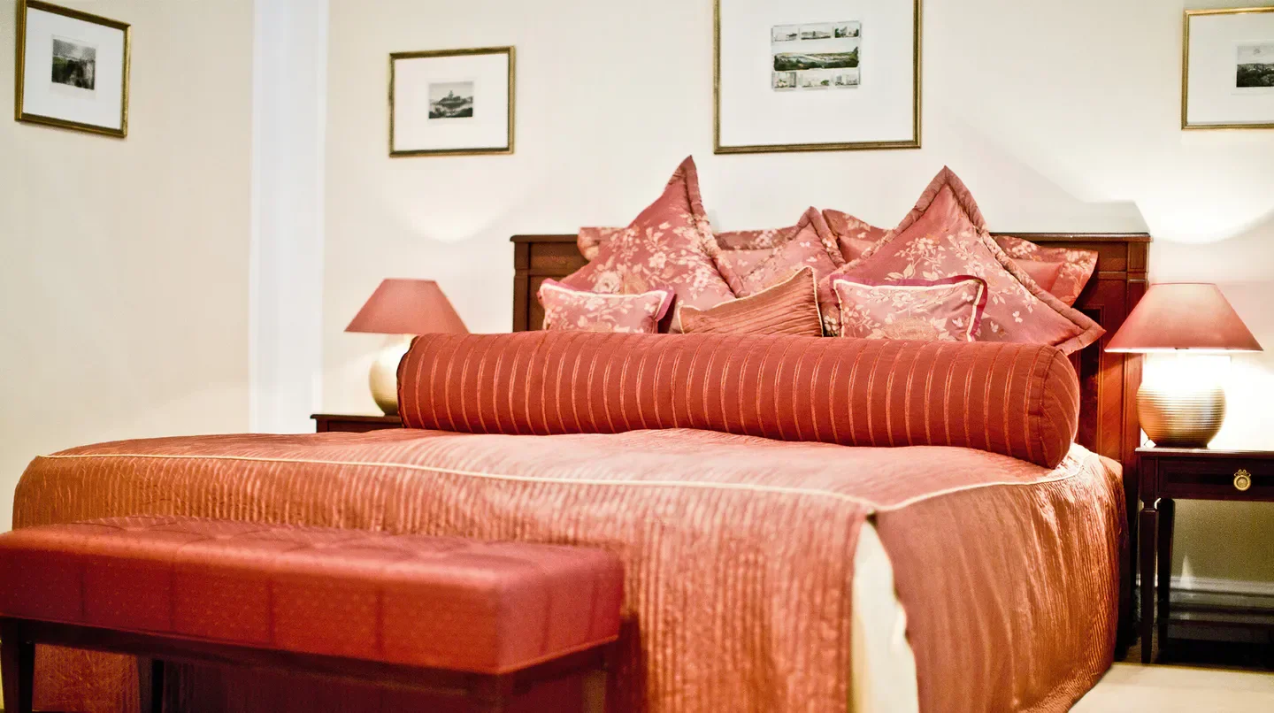 Cozy bedroom at Palais Coburg hotel in Vienna, featuring elegant bedding and decor
