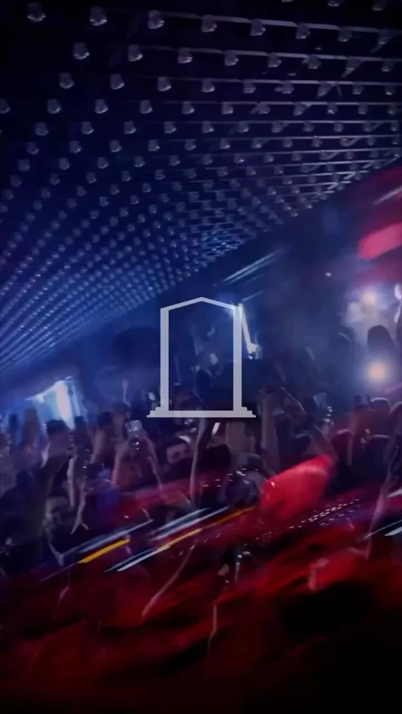 Energetic crowd at Pantheon III nightclub with blue and red ambient lighting.