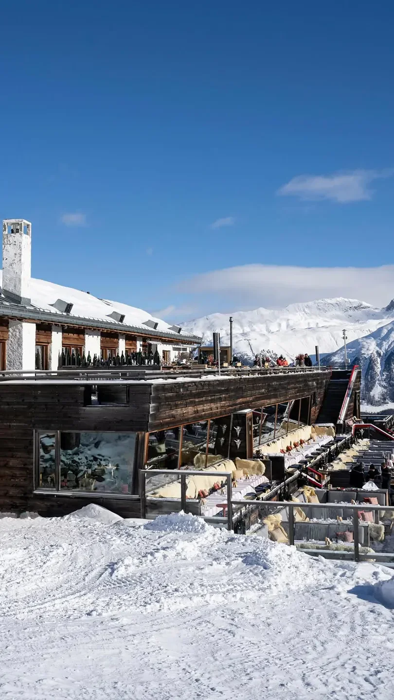 Outdoor dining at Paradiso Mountain Club & Restaurant in St. Moritz with snowy mountain views
