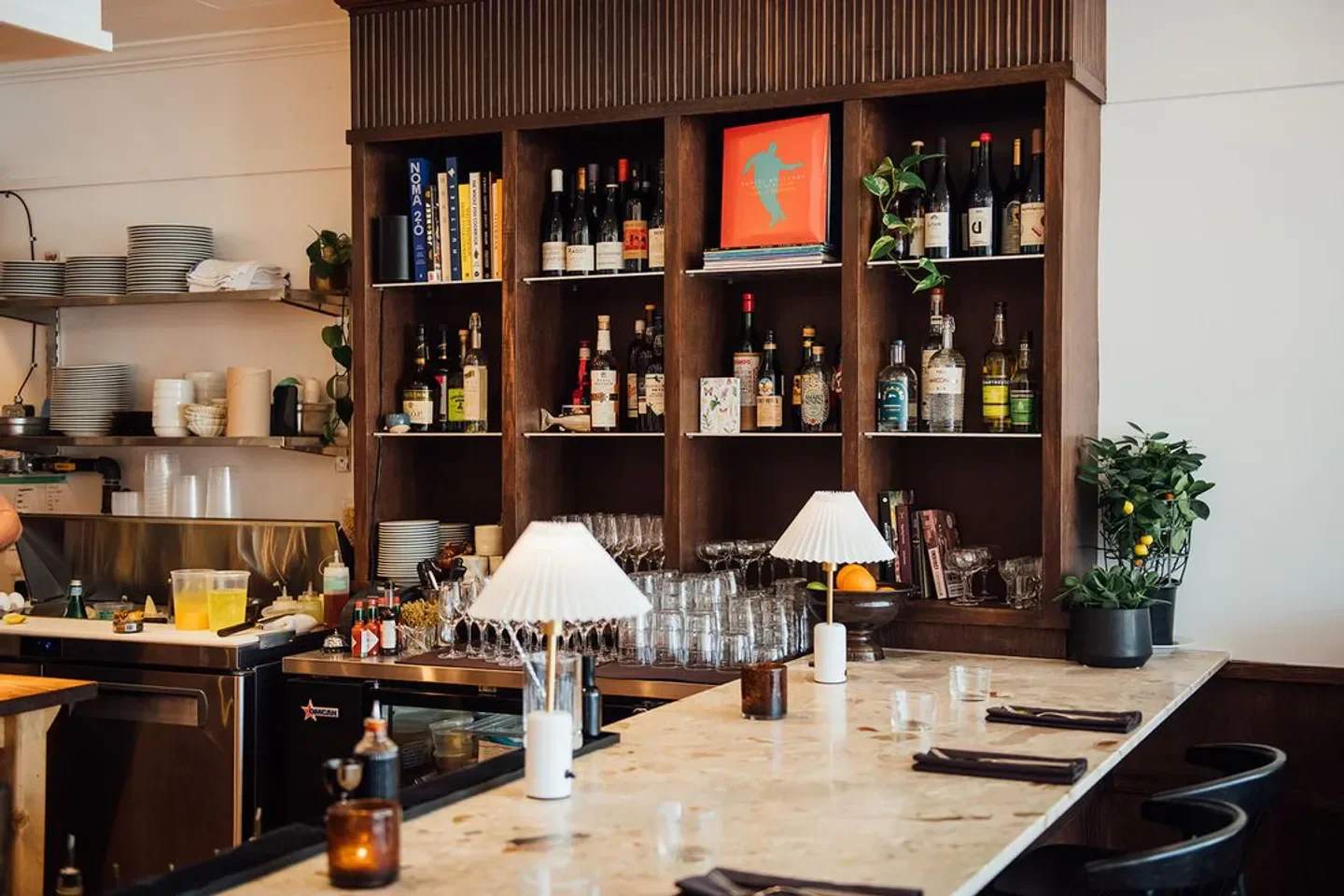 Interior shot of Parapluie restaurant in Montreal, with bar, shelves and bottles.