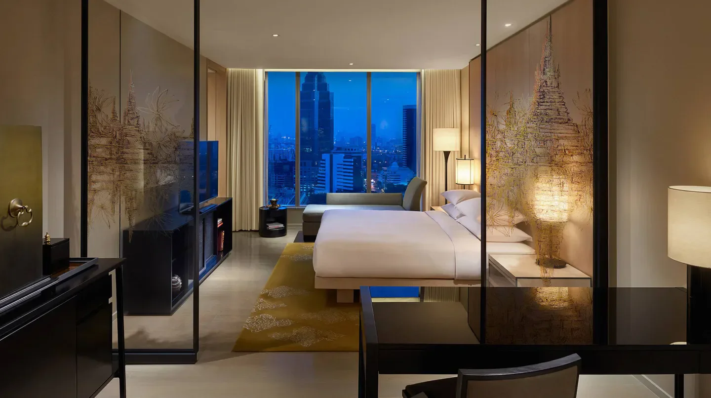 Luxury bedroom at Park Hyatt Bangkok with stunning city views of Bangkok at dusk