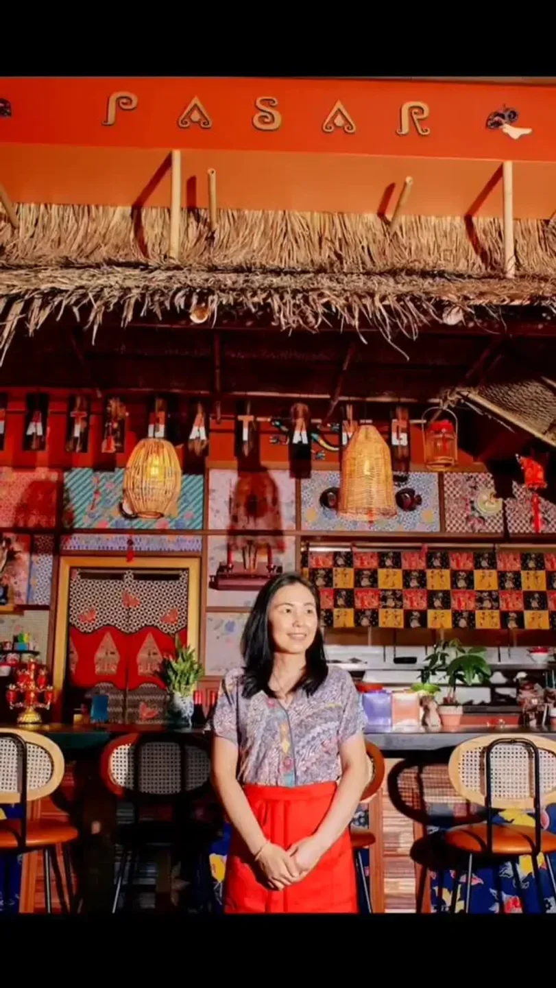 Pasar Portland restaurant interior with woman, unique decor, and woven lamps.