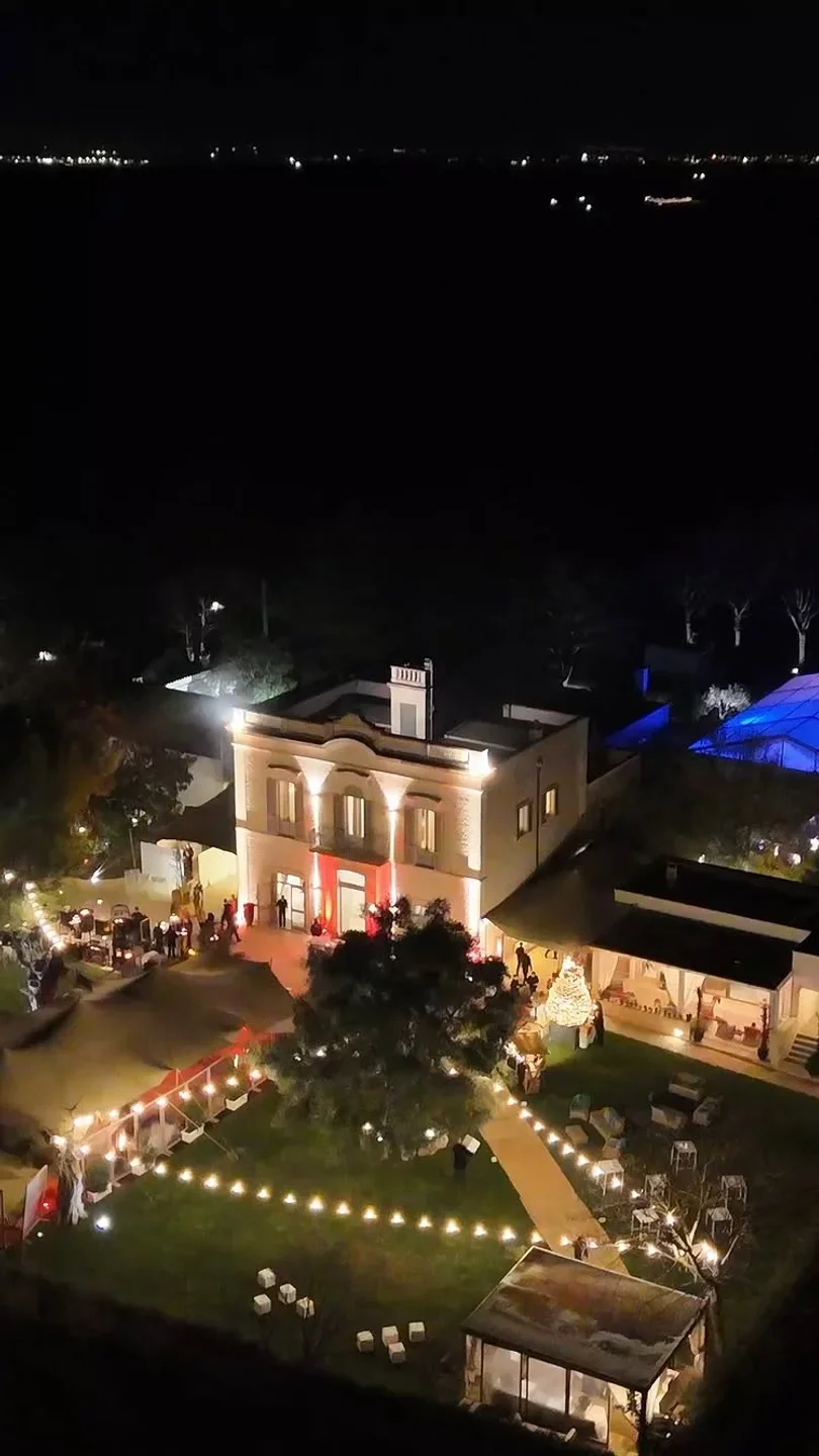 Exterior view of Pashà restaurant in Puglia, Italy at night with beautiful outdoor lighting and decorations.