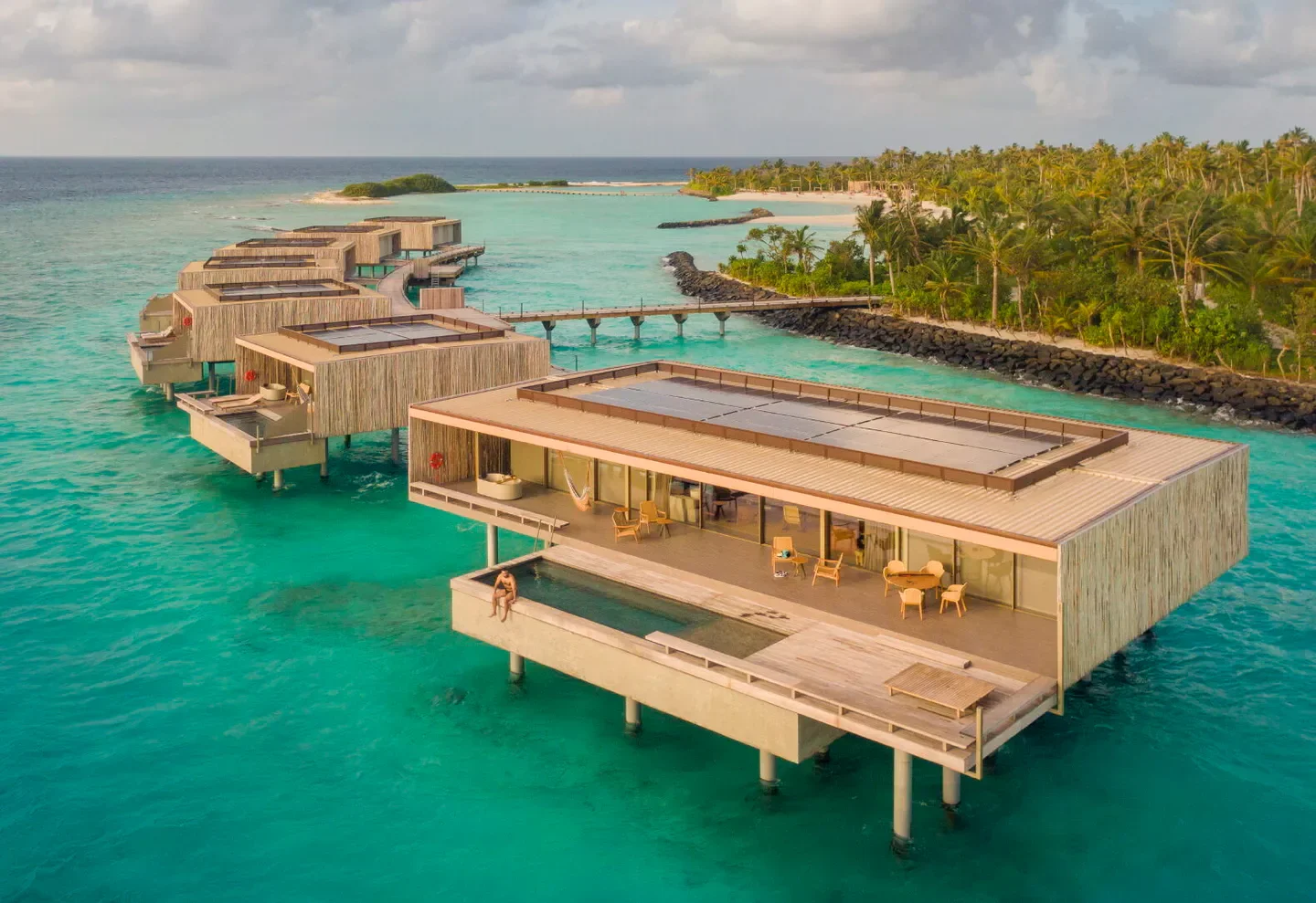 Overwater bungalows at Patina Maldives, Fari Islands in the Maldives with turquoise waters.