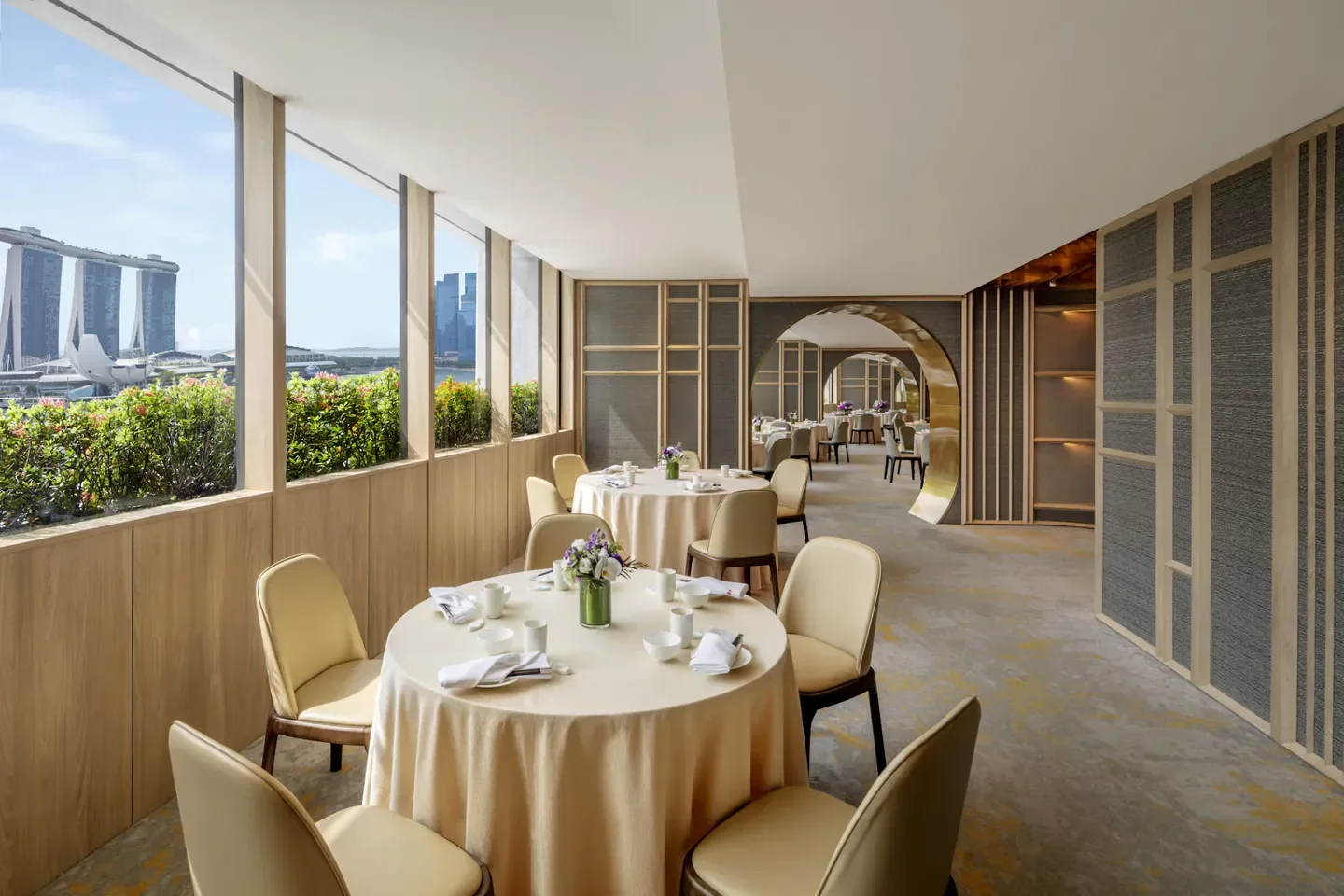 Elegant dining room at Peach Blossoms restaurant in Singapore with city views.