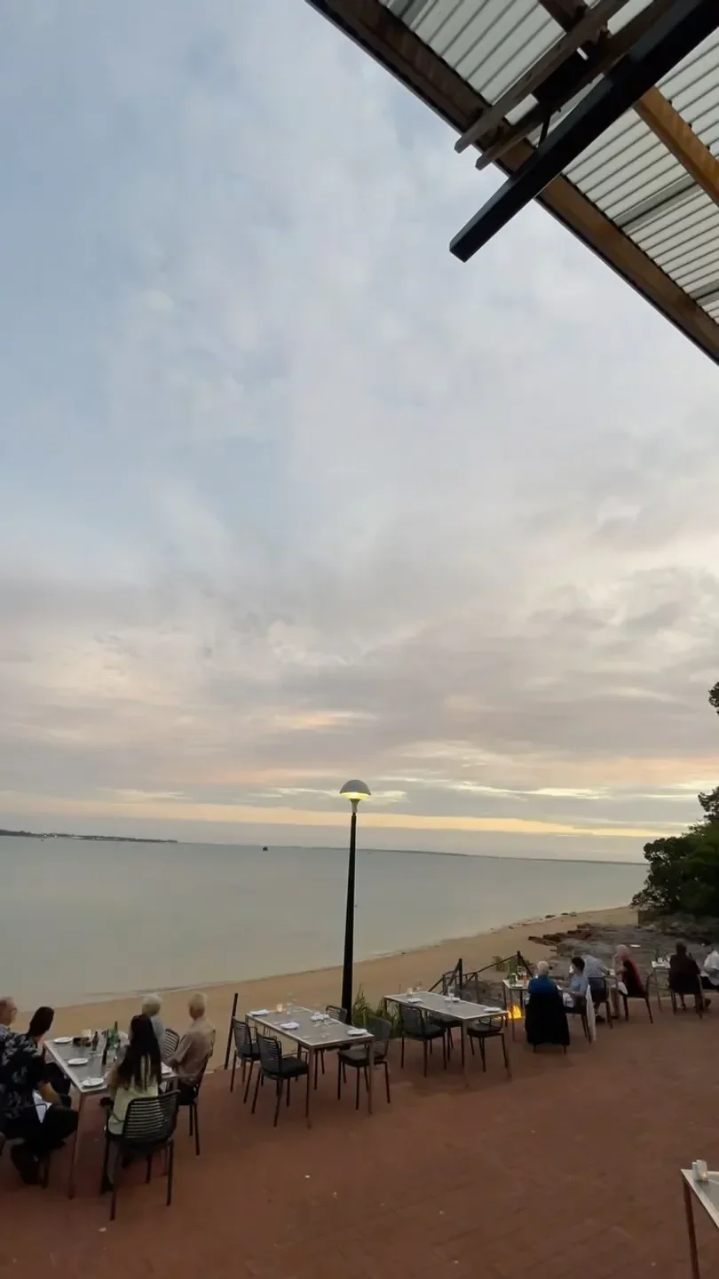 Tables set at Pee Wee's at the Point in Darwin, overlooking the beach at sunset.