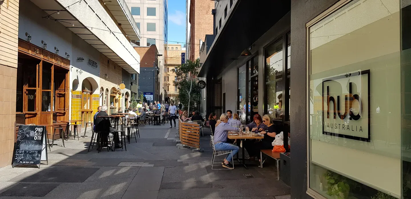 Outdoor dining scene on Peel St in Adelaide, with people enjoying meals and drinks.