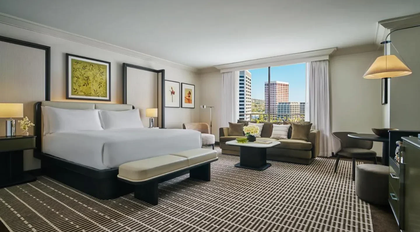 Spacious suite interior at Pendry Newport Beach, offering city views of San Diego.
