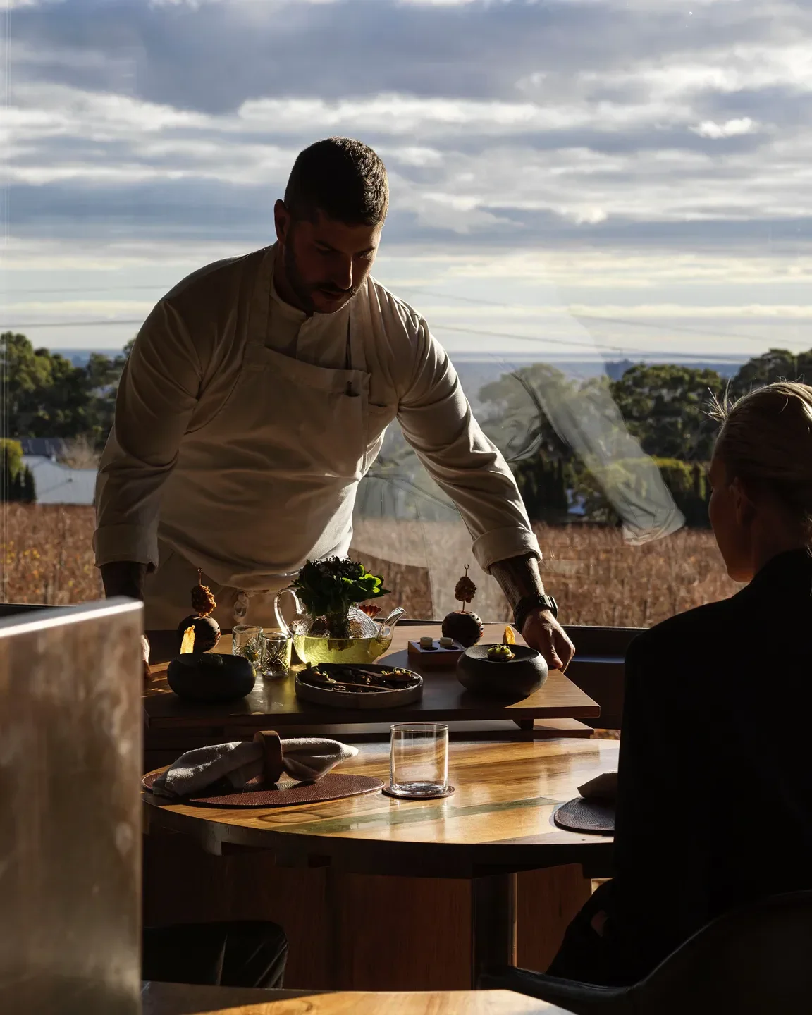 Chef serving at Penfolds Magill Estate Restaurant in Adelaide with scenic views.