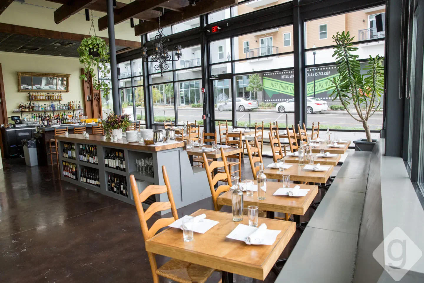 Interior of Peninsula restaurant in Nashville with tables set and a well-stocked bar