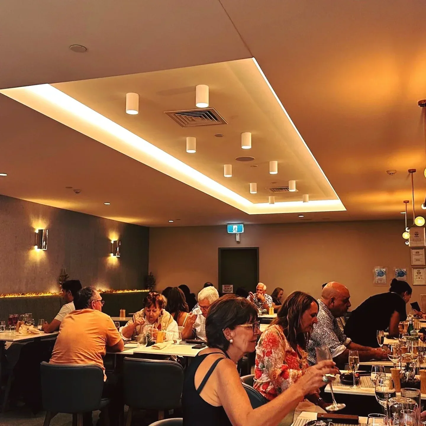 Dining experience at PepperBerry restaurant in Darwin, with warm lighting and happy customers.