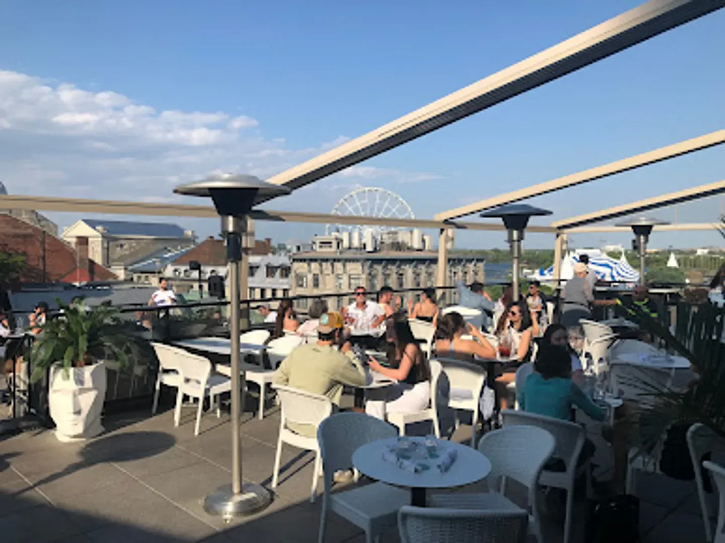 Rooftop dining at Perché restaurant in Montreal, with city views and outdoor heaters.