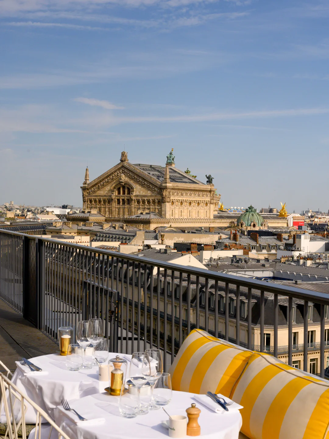 Rooftop view from Perruche restaurant in Paris with table setting overlooking historic buildings