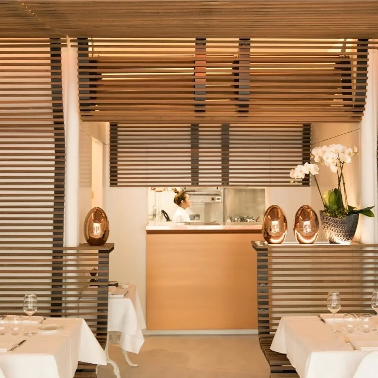 Interior of Pertinence restaurant in Paris featuring stylish decor, tables, and a glimpse of the kitchen