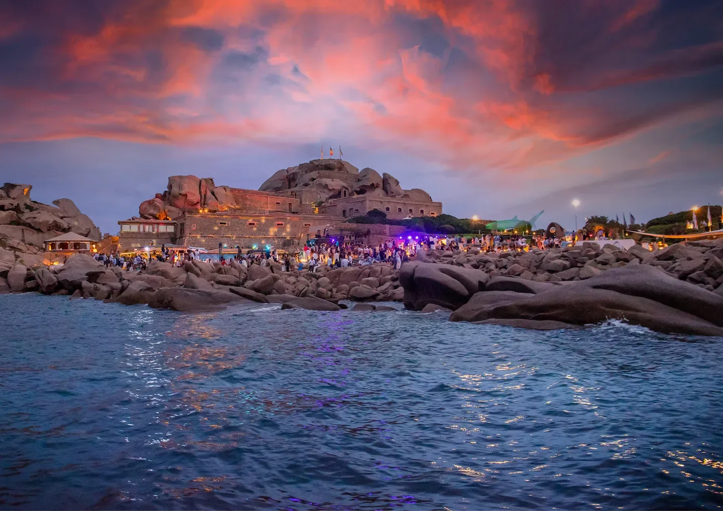 Sunset at Phi Beach in Porto Cervo, with people dining by the water