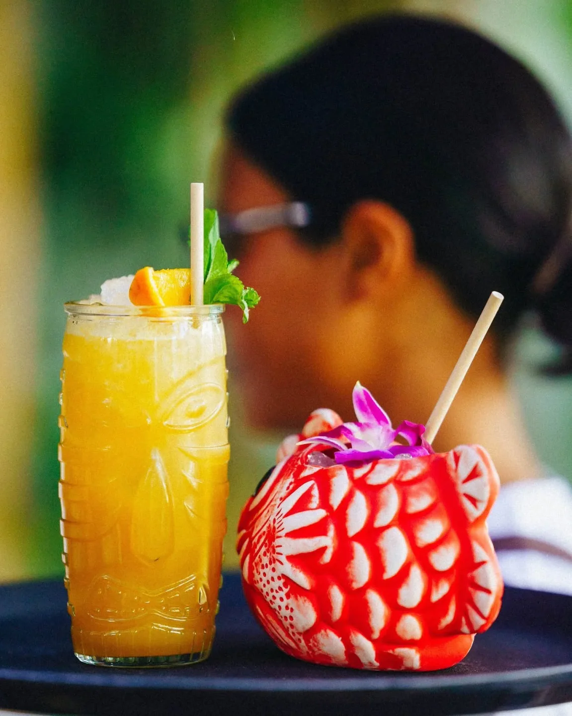 Pica Pica Puente Romano offers vibrant, tropical tiki cocktails garnished with fruit and flowers.